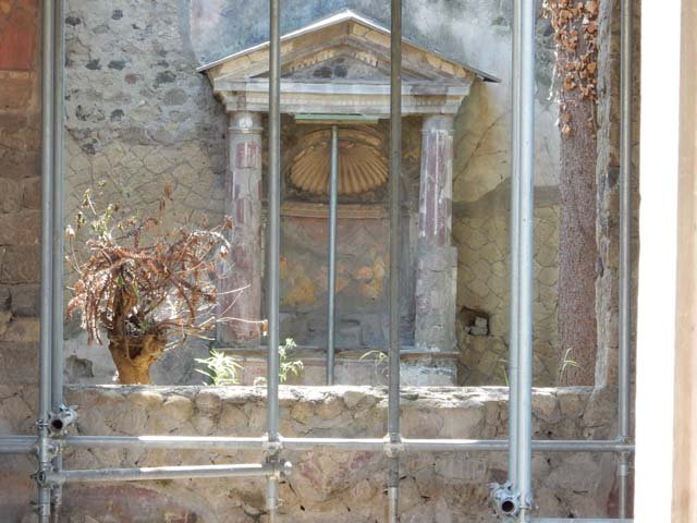 Ins. V 5, Herculaneum, September 2015. Looking from window of tablinum towards garden and shrine. The little courtyard, closed all around by a parapet and paved in opus signinum was chiefly designed to carry away the rainwater to the cistern.
It was decorated with an aedicula lararium. 
