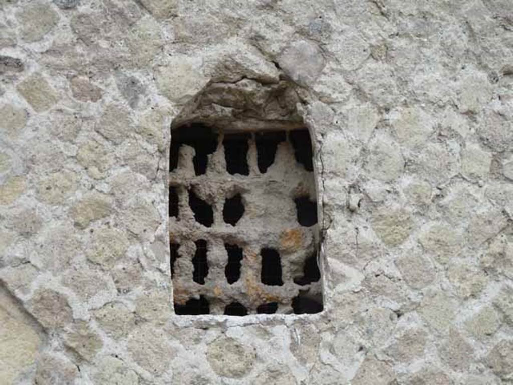 V.8 Herculaneum, May 2010. Detail of window in exterior west wall of houses on east side of Cardo IV Superiore.