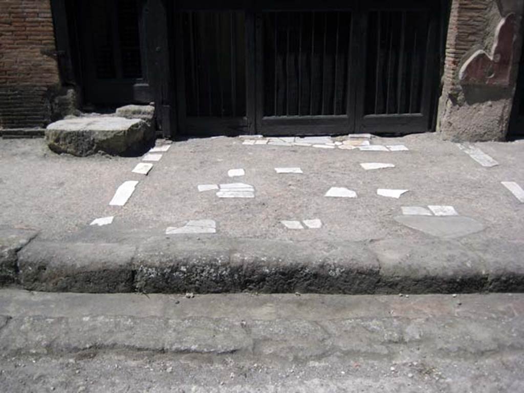 V.17 Herculaneum, June 2008. Pavement outside entrance to V.17, on right, and steps to upper floor at V.18, on left.
Photo courtesy of Nicolas Monteix. 

