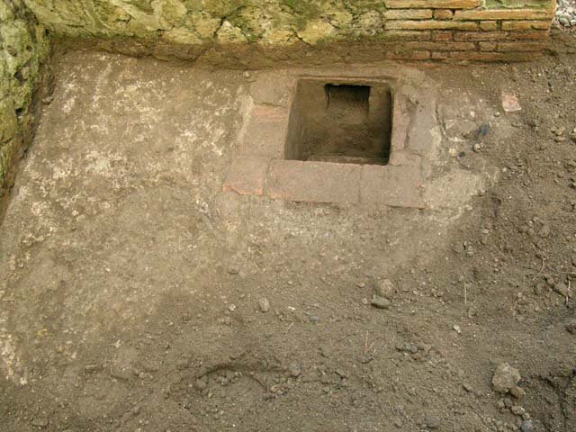 Ins Or II, 6, Herculaneum. December 2004. Hole/drain in south-west corner of shop/bar-room. 
Photo courtesy of Nicolas Monteix.
