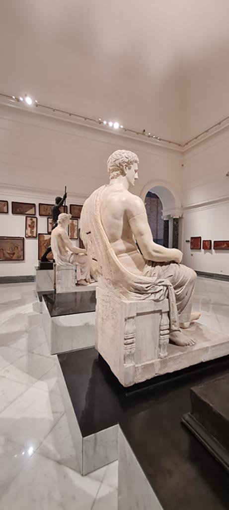 Herculaneum Augusteum. April 2023. 
Rear of white marble statue of Claudius, inv. 6056. 
Photo courtesy of Giuseppe Ciaramella.
