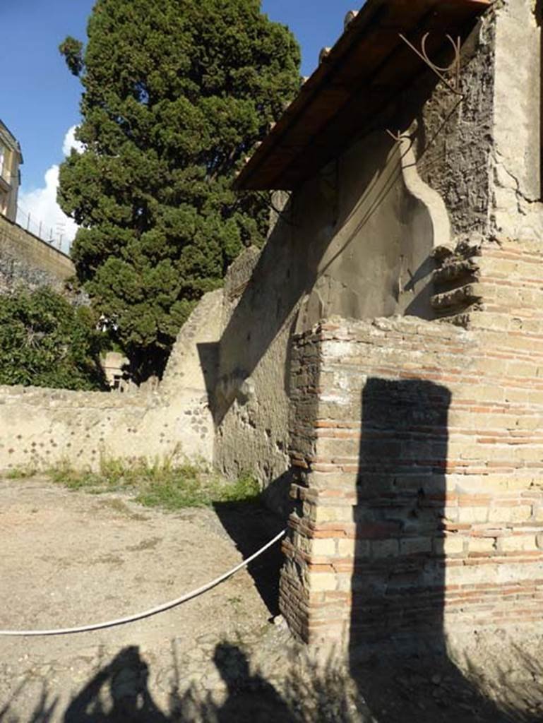 II.2 Herculaneum, September 2015. 
Looking through entrance doorway towards east side of wide rectangular exedra on north side of peristyle.
According to the Herculaneum guidebook, this house was named from a fresco, now lost, which was painted on one of the walls of this exedra.
The painting showed Argo who guarded Io, the nymph loved by Zeus and who was transformed into a heifer.
See Guidobaldi, M.P, 2009. Ercolano, guida agli scavi, Napoli, Electa, (p.54)
According to Pagano and Prisciandaro, on 23rd December 1828 –
“A large and beautiful exedra or receiving room began to come out into the light (Table 12, no.14).
Its floor must have been one of the most superb since it was in various places covered with large slabs of exotic and precious marbles. A picture that showed Mercury trying to distract Argo and kidnap the beautiful Io was in one side of this room, now fallen, and was surrounded by trophies and decoration of the most precious style. Bonnucci”. Ref: StErc 559.
(23 dic 1828. “Una grande e bella exedra o sale di ricevimento incominicia a comparire alla luce (Tav XII, numero 14). Il suo pavimento deve essere dei piu superbi mentre era in vari punti ricoverto di grandi lastre di marmi esotici e preziosi. Un quadro che esprime Mercurio che tenta di adormentare Argo e rapirgli la bella Io e in un lato di questa stanza, ora caduto, ed era circondato da trofei e da decorazione dell’ piu pregiovole stile. Bonnucci”.
See Pagano, M. and Prisciandaro, R., 2006. Studio sulle provenienze degli oggetti rinvenuti negli scavi borbonici del regno di Napoli. Naples: Nicola Longobardi. (p.225).

