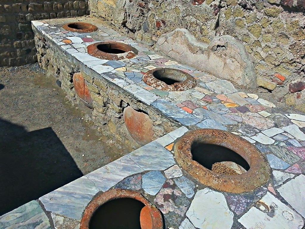 II.6/7 Herculaneum, photo taken between October 2014 and November 2019. 
Looking south along western side of counter/podium. Photo courtesy of Giuseppe Ciaramella.
