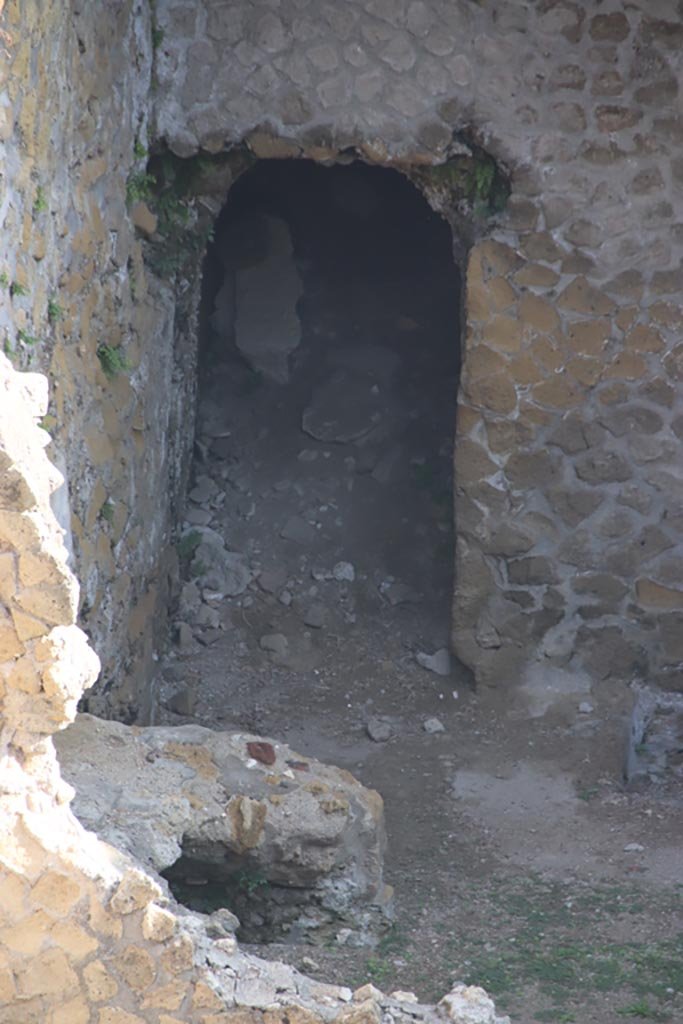 III.1/2/18/19, Herculaneum, October 2023. 
Doorway in north wall of room G, with remains of oven/hearth against west wall. 
Photo courtesy of Klaus Heese.

