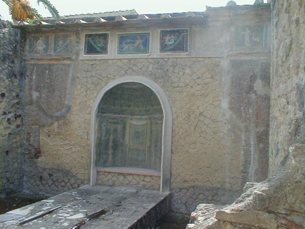 III.3 Herculaneum. September 2004. Nymphaeum against east wall. According to Guidobaldi and Esposito, the blue-ground mosaic decoration of this niche has now been removed to Naples Archaeological Museum. Above the niche, a frieze of seven mosaic panels ran across the rear wall. Six of these mosaic panels survived, three in situ, and three in Naples Museum.
See Guidobaldi, M.P, and Esposito, D. (2013). Herculaneum – Art of a Buried City. U.S.A, N.Y, Abbeville Press, (p.287).
