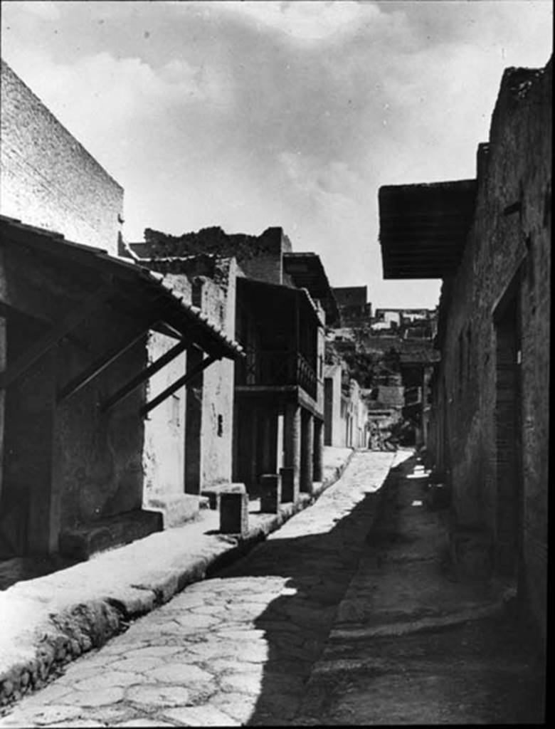 Cardo IV Inferiore, Herculaneum. 1935. Photo by Fratelli Alinari (I.D.E.A.). Alinari No 43137 (1935) oN.  Looking north from III.17, Casa dell’Ara Laterizia or House of the Brick Altar, on left, and IV.2, Casa dell’ Atrio a mosaico or House of the Mosaic Atrium, on right.  The colonnade in the centre of the photo is outside III.14, Casa a Graticcio or House of the Wattle Work (Opus Craticium),  Used with the permission of the Institute of Archaeology, University of Oxford. File name instarchbx116im013 Resource ID 42232.
