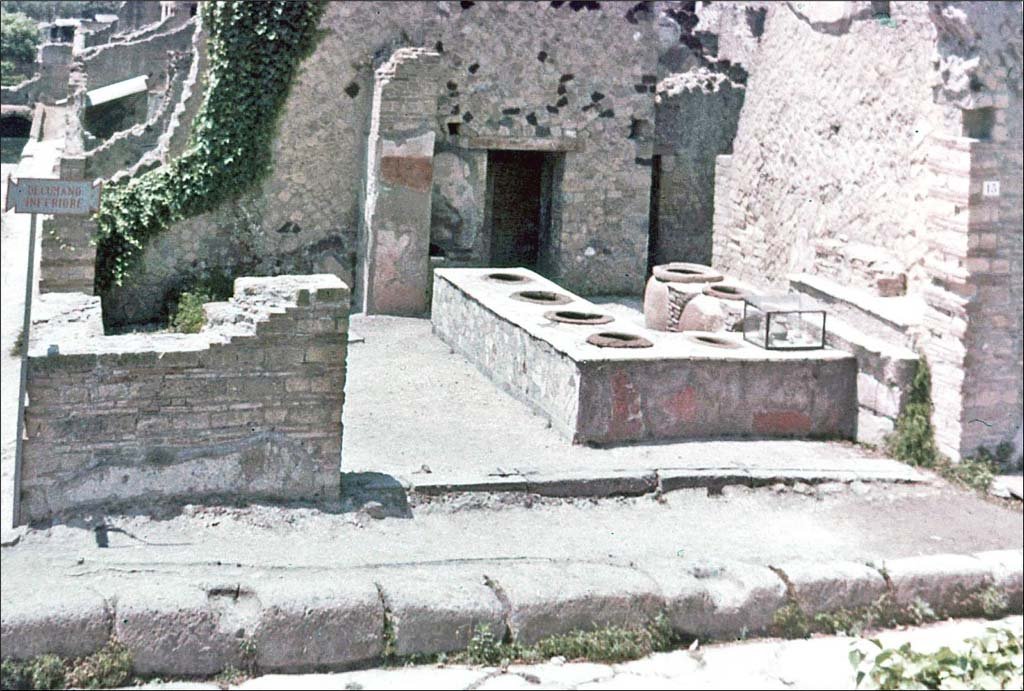 IV.15 Herculaneum, June 1962. Looking south towards entrance doorway on Decumanus Inferiore.
Photo by Brian Philp: Pictorial Colour Slides, forwarded by Peter Woods
(H42.4 Herculaneum Thermopolium at crossroads).

