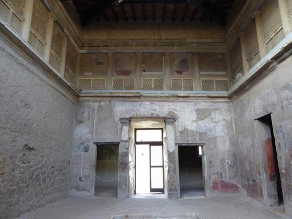 V.1, Herculaneum, October 2014. Looking west in atrium. West wall of atrium, with doorways to room 3, on left, the entrance corridor and room 2, on right.  The upper floor is decorated as a false loggia.  Photo courtesy of Michael Binns.
