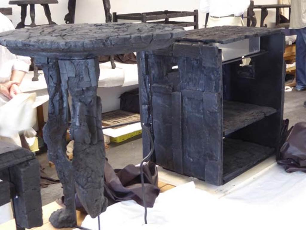 V.5 Herculaneum, September 2016. 
Reverse side of carbonised wooden table, this with circular top and three legs decorated with greyhounds.
Photo courtesy of Michael Binns.
See De Carolis, E. (2007). Il mobile a Pompei ed Ercolano, letti tavoli sedie e armadi. Rome, “L’ERMA” de Bretschneider, (p.100) 
