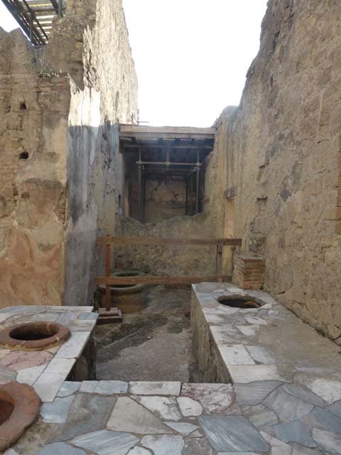 V.10, Herculaneum, September 2015. Looking south across counter with inset dolia (pots).