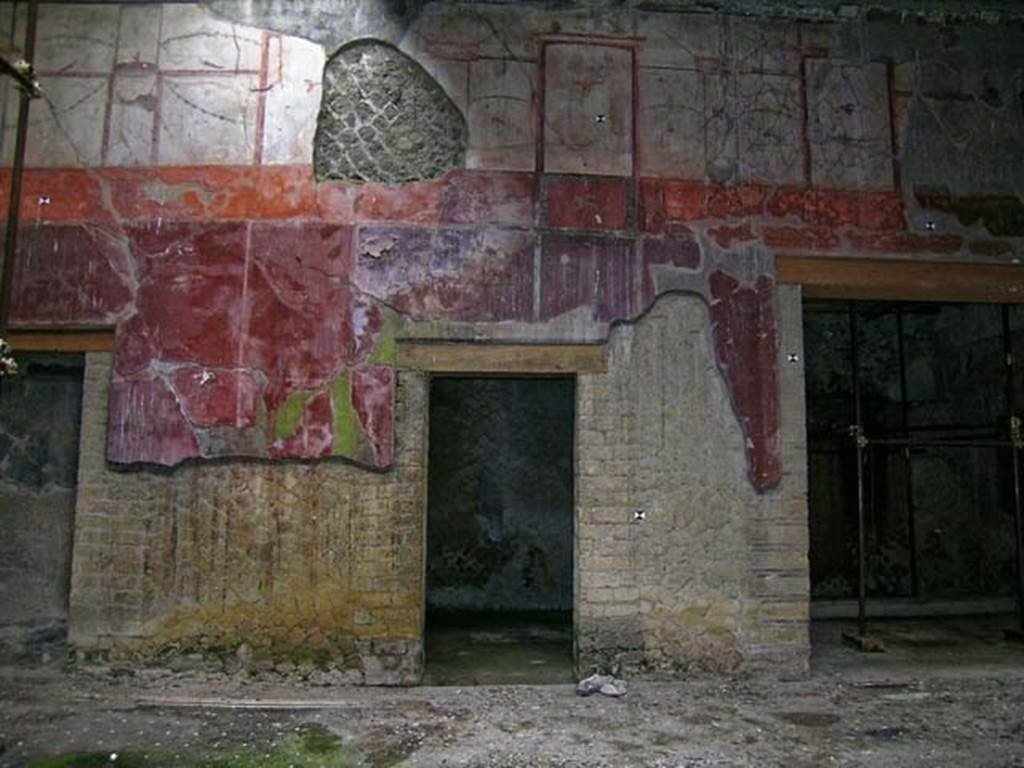 V.15 Herculaneum. May 2004. East side of atrium with room in centre and doorway to east ala, on right. Photo courtesy of Nicolas Monteix.
Maiuri described this central room as having – 
“fine decoration on white background with golden candelabra at the centre and animal motifs in the area of the paintings”.
