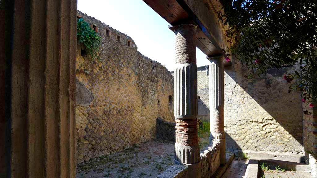 V.15 Herculaneum. August 2021. 
Looking south across east portico towards kitchen area, with niche in both the east and south walls. Photo courtesy of Robert Hanson.
