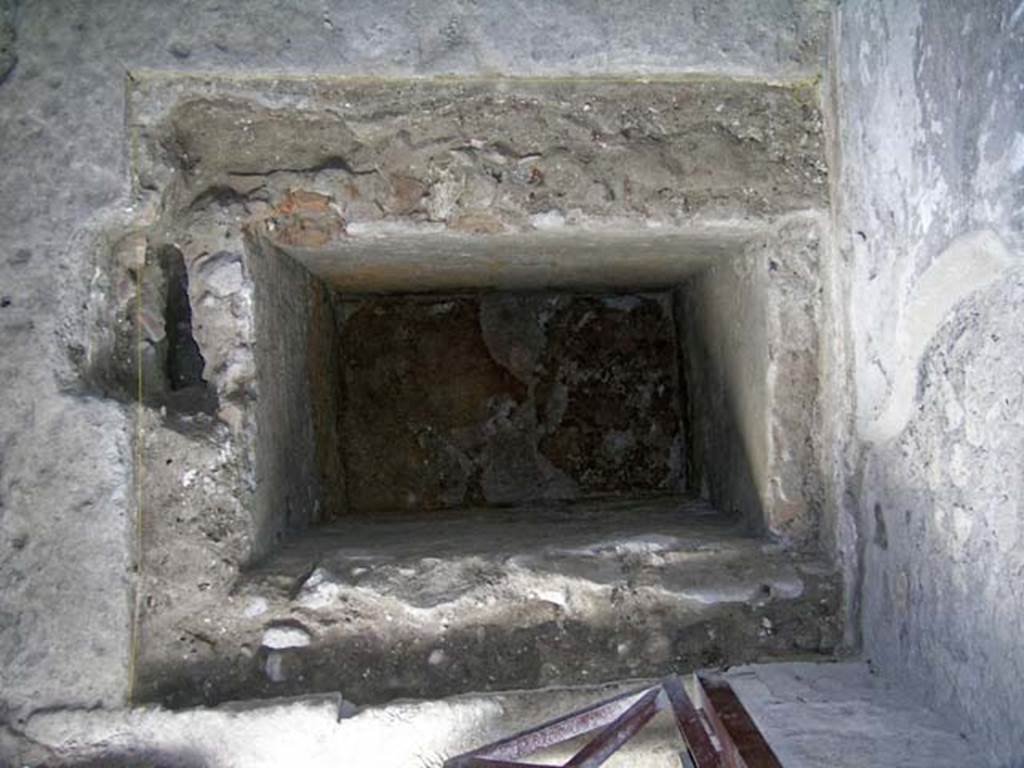 VI.15, Herculaneum. September 2004. 
Excavation in north-west corner, entrance doorway in lower photo, looking south across rectangular pit. 
The rectangular pit in the centre of the room (0.50m by about 0.70m) was filled with eruptive material, proving that it had been open at the time of the eruption and was then filled by the pyroclastic material. This open pit would certainly have disrupted any commercial activity in the shop.
Photo courtesy of Nicolas Monteix.
