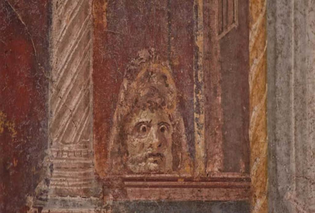 VI.21, Herculaneum, April 2018. Decorative painted mask from south end of central painting on east wall. Photo courtesy of Ian Lycett-King. Use is subject to Creative Commons Attribution-NonCommercial License v.4 International.
