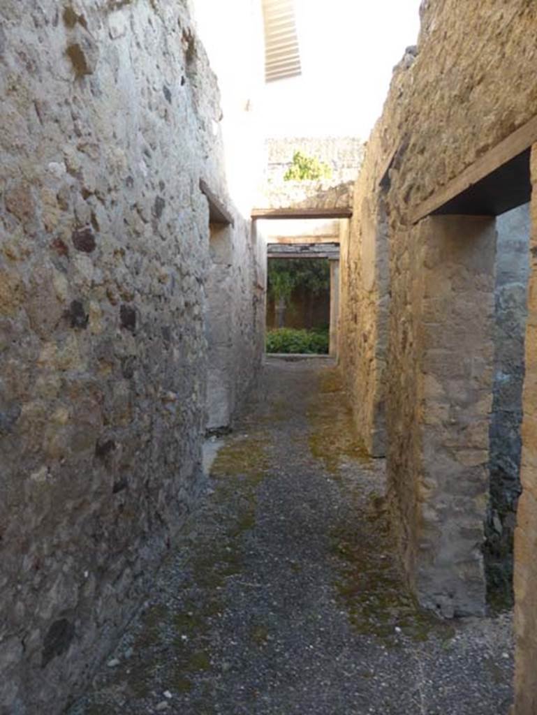 VI 26, Herculaneum, September 2015. Looking east along the long corridor towards peristyle, from rear entrance doorway. The doorway in the north wall, on the left, leads into the kitchen. The two doorways on the right lead into two rooms used as storerooms/cupboards in the services area.
