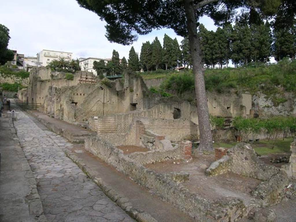 Ins. Orientalis I.3, Herculaneum, May 2004. 
Looking towards area of house and garden of Telephus Relief on its north-western side, lower centre right.
The aedicula lararium can be seen against the north wall of the garden area.
This rustic area occupied all the area on the north side of the house. 
In the centre of the photo, would be the area of room C, on its south side would be room A, with a doorway into room B on its south side.
Room D with the three stoves, is on the extreme right, behind room B. On the left is Cardo V, looking north. 
Photo courtesy of Nicolas Monteix.
The rustic area was composed of a stable with ramp, and a garden, with some rooms on the south and west sides.
These rooms may have been turned into a commercial use, during their last days. 
In one of the rooms, (room B), the floor was completely covered with tiles, as often seen in a workshop of a laundry. 
In another, (room D), a set-up of three stoves would probably have been used for the industry carried out in workshop B.



