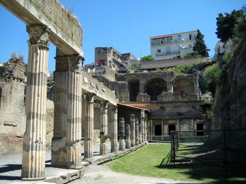 Ins. Orientalis II.4, Herculaneum, June 2011.  
Looking north-west from exit doorway of the unexcavated palaestra, towards rooms on loggia on north side, with modern Ercolano towering above. Photo courtesy of Sera Baker.
