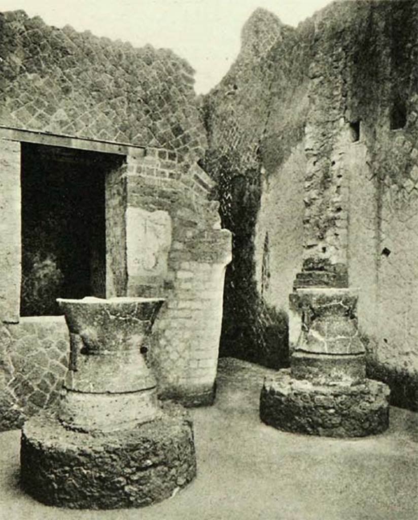 Ins. Or. II, 1a, Herculaneum. 1958. Room A, mills (m’) and (m).
Looking north towards window into room B, and doorway to room b, with painted remains of lararium.
According to Maiuri –
“Sulla parete di fronte restano gli avanzi d’una pittura di larario: vi si riconosce a stento parte di un’ara colma di offerte di frutta e in basso, da uno dei lati, un porco.”
(On the facing wall there are the remains of a lararium painting: here you can just recognise part of an altar full of fruit offerings and at the bottom, on one of the sides, a pig.)
See Maiuri A., 1958. Ercolano I Nuovi Scavi (1927-1958) Vol. 1. Roma: Istituto Poligrafico dello Stato, (p. 452, fig. 403 & p.453).

