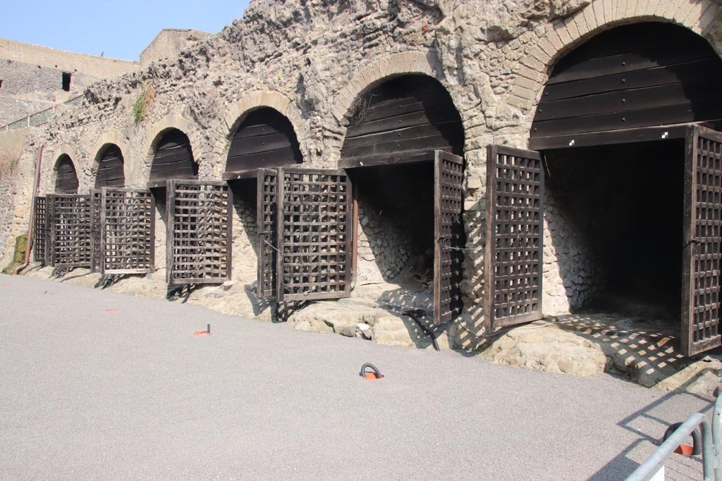 Beachfront, Herculaneum, September 2015. Looking west along the area of the beachfront and six of the twelve “boatsheds”, found under the terrace of the Sacred Area.  “Since the 1980’s the ancient shoreline, coinciding with the southern side of the archaeological site, has been explored leading to the discovery of the boat-houses, the skeletons of the victims, the large wooden boat and the collapsed portico (pronaos) of the Temple of Venus (Sacellum B). 
The resin casts of the skeletons found in the boat-houses, finally placed in situ at the end of 2011, now give visitors a vivid image of the last, painful moments of their lives.”
See Guidobaldi, M.P. and Esposito, D. (2013). Herculaneum: Art of the Buried City. U.S.A, Abbeville Press, (p.21-26).  
