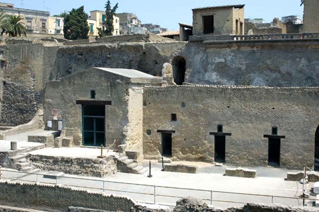 Herculaneum, July 2007. Looking north from access roadway towards Sacred Area terrace, lower part of photo.
Above and behind the terrace, in the centre of the photo, is the vaulted exit from the ramped passageway at the south end of Cardo IV. Inferiore.
Photo courtesy of Jennifer Stephens. ©jfs2007_HERC-8623.
