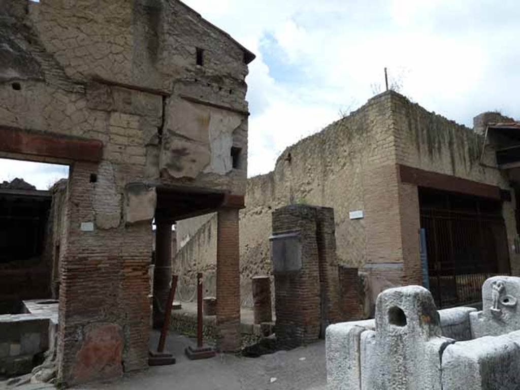 Decumanus Maximus, Herculaneum. May 2010. Shop V.10 on left, north end of Cardo IV with water tower, street altar and fountain, and VI.12, on right.
Looking south-west.     

